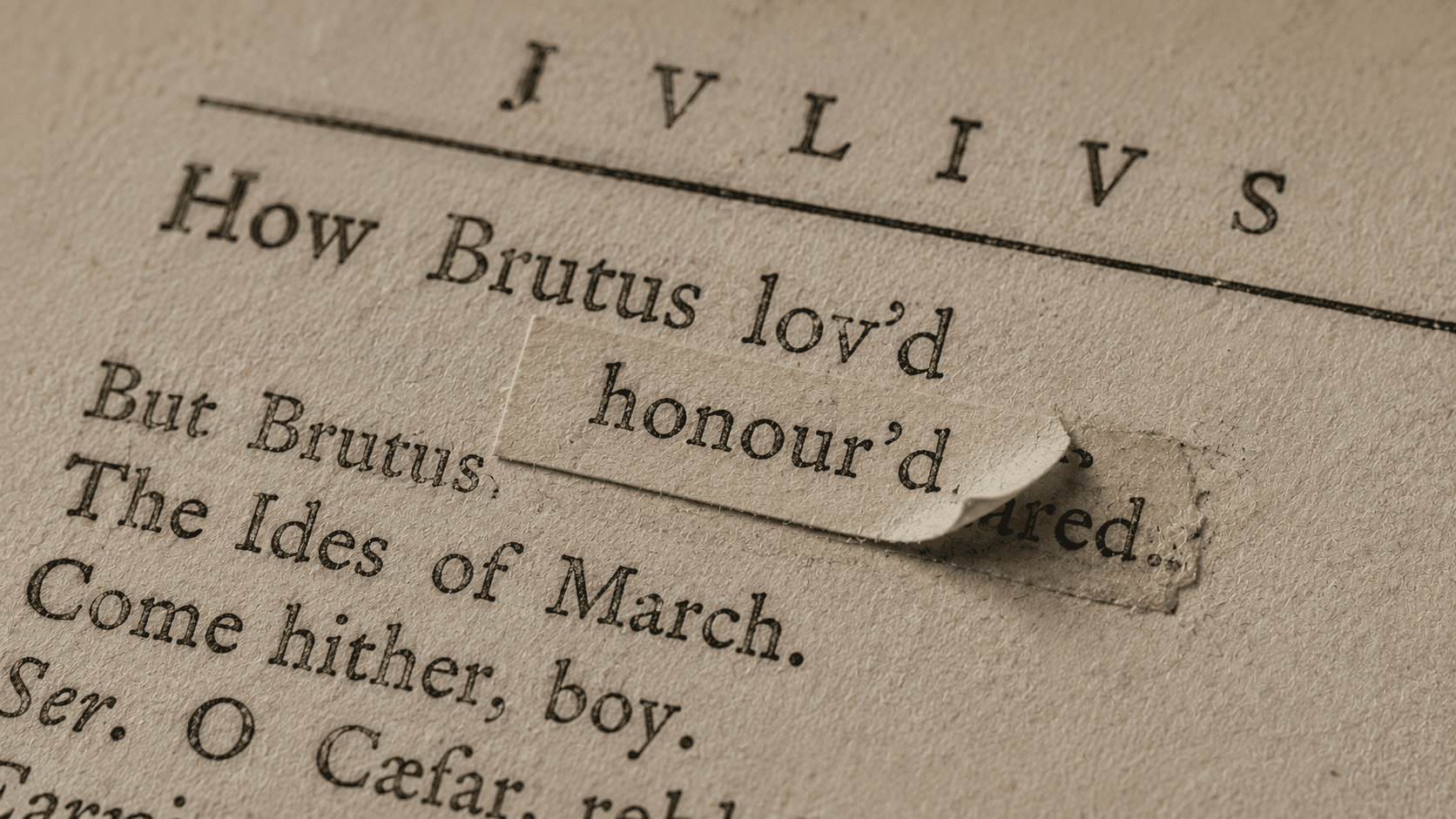 Close view of a small printed correction slip pasted over a word on an old book page.